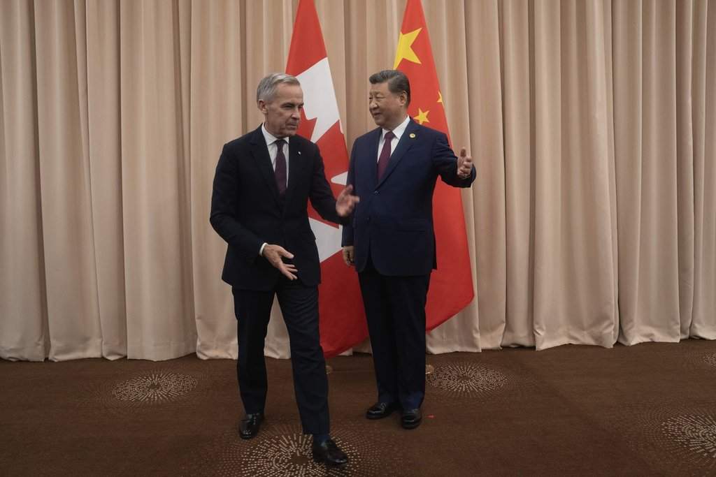 Canadian Prime Minister Mark Carney, left, and Chinese President Xi Jinping gesture toward their seats at the start of a meeting in Gyeongju on Friday, Oct. 31, 2025.