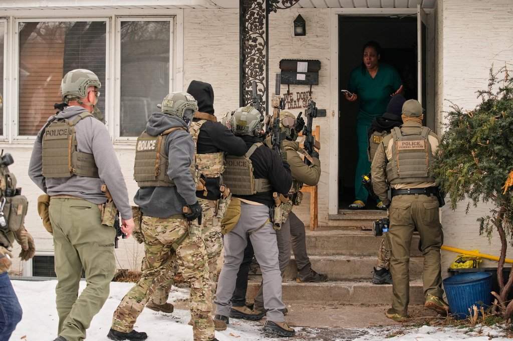 A family member reacts after a federal immigration officer used a battering ram to break down a door before making an arrest Sunday, Jan. 11, 2026, in Minneapolis.