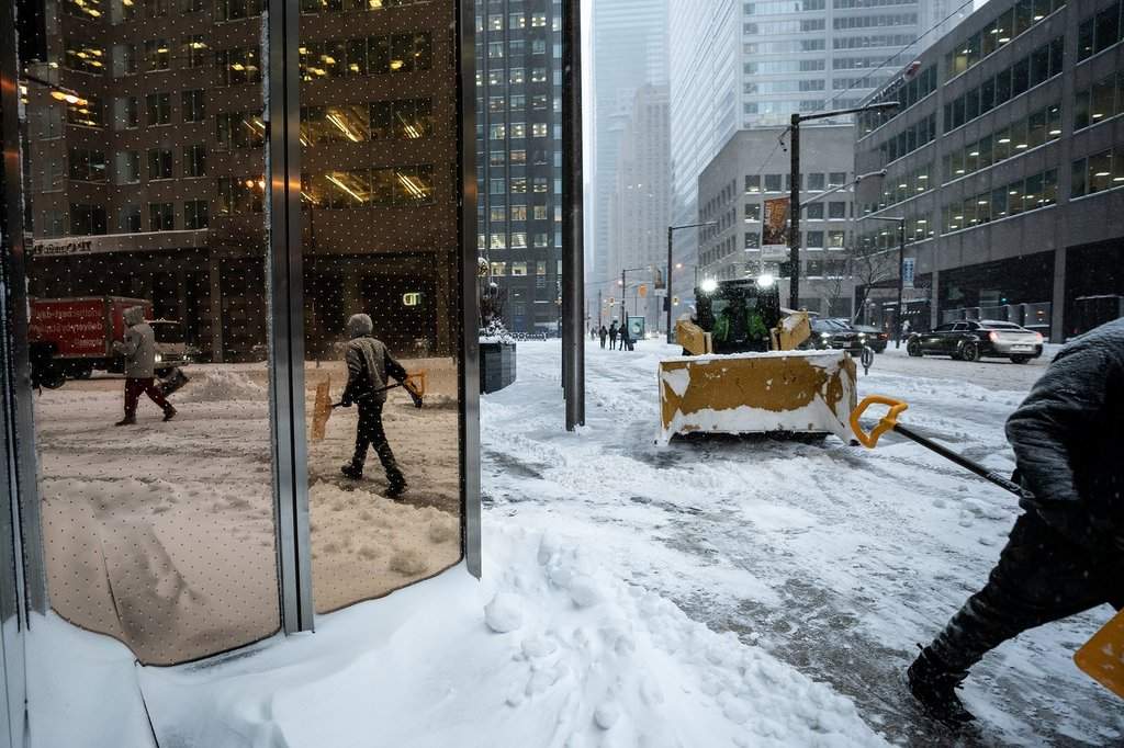 Workers remove snow amid heavy snowfall and accumulation as snow and heavy winds continue to hammer the Greater Toronto Area, in Toronto, Thursday, Jan. 15, 2026. THE CANADIAN PRESS/Giordano Ciampini.