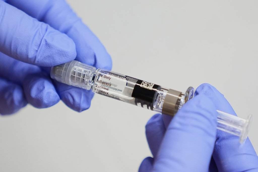 FILE - A certified medical assistant holds a syringe for a flu vaccine at a clinic in Seattle, on Sept. 10, 2025. (AP Photo/Lindsey Wasson, File).