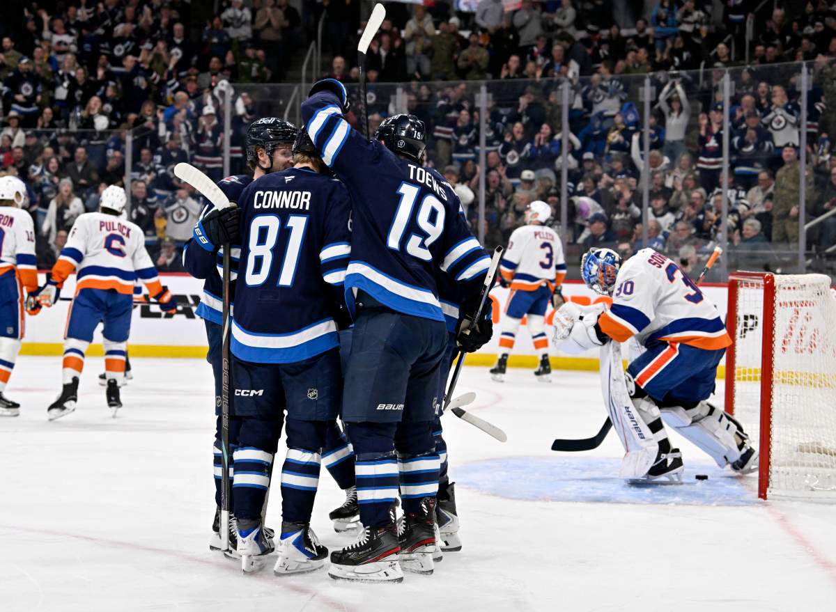 Winnipeg Jets' Jonathan Toews (19) celebrates his goal on New York Islanders goaltender Ilya Sorokin (30) with Kyle Connor (81) and teammates during the second period of their NHL hockey game in Winnipeg, Tuesday January 13, 2026. THE CANADIAN PRESS/Fred Greenslade.