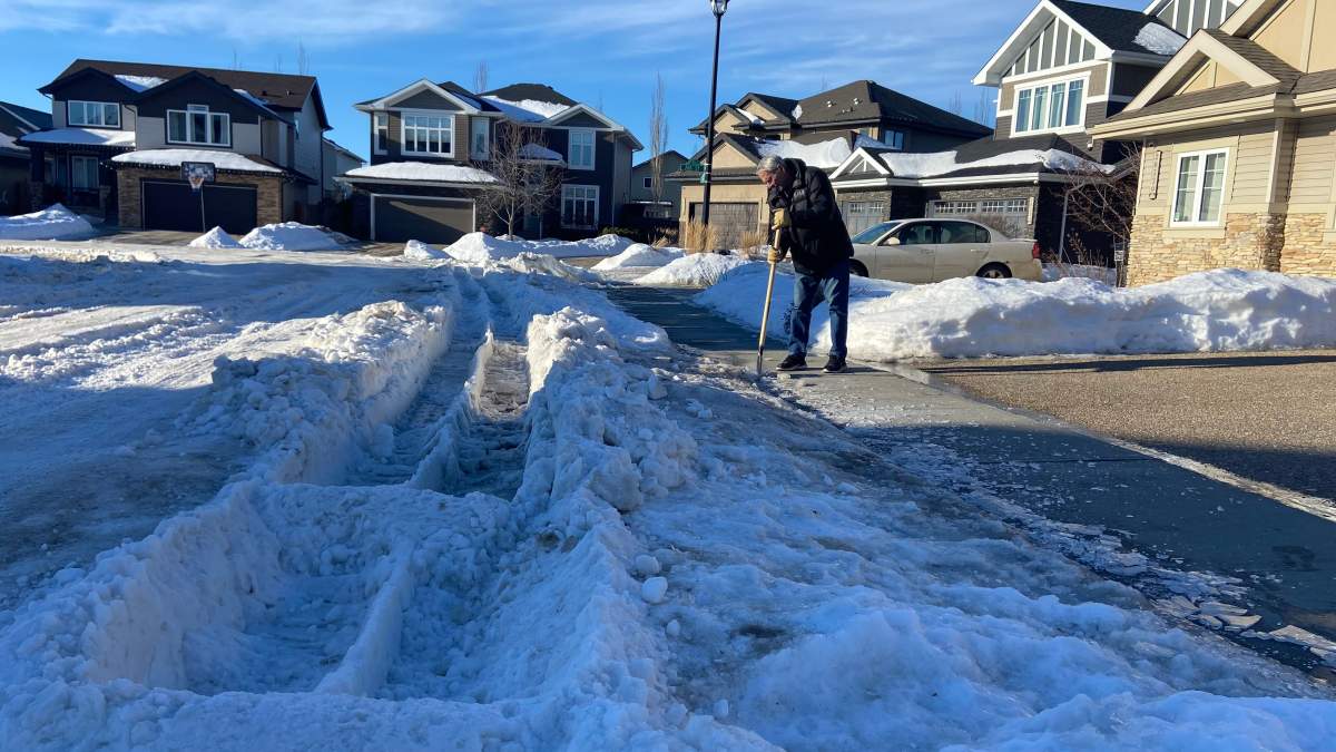 Resident Doug Marchesi trying to chip away ice near a big windrow rut left by a garbage truck in his Edmonton neighbourhood. Friday, January 16, 2026.