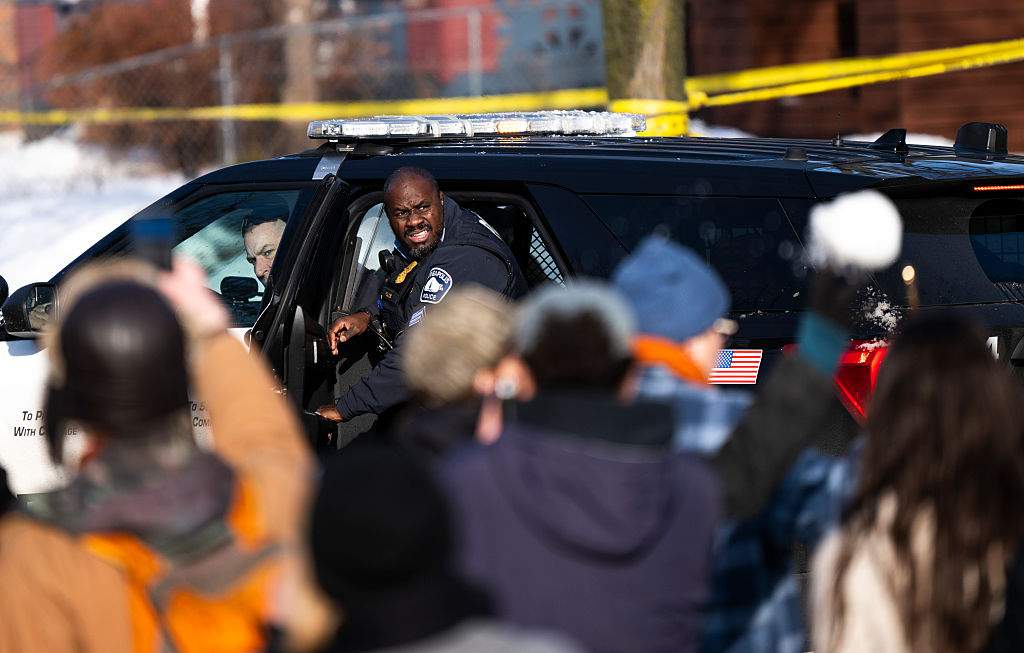 A Minneapolis Police officer reacts as their vehicle is hit by snowballs as they leave the scene after a shooting by an ICE agent during federal law enforcement operations on January 07, 2026 in Minneapolis, Minnesota.