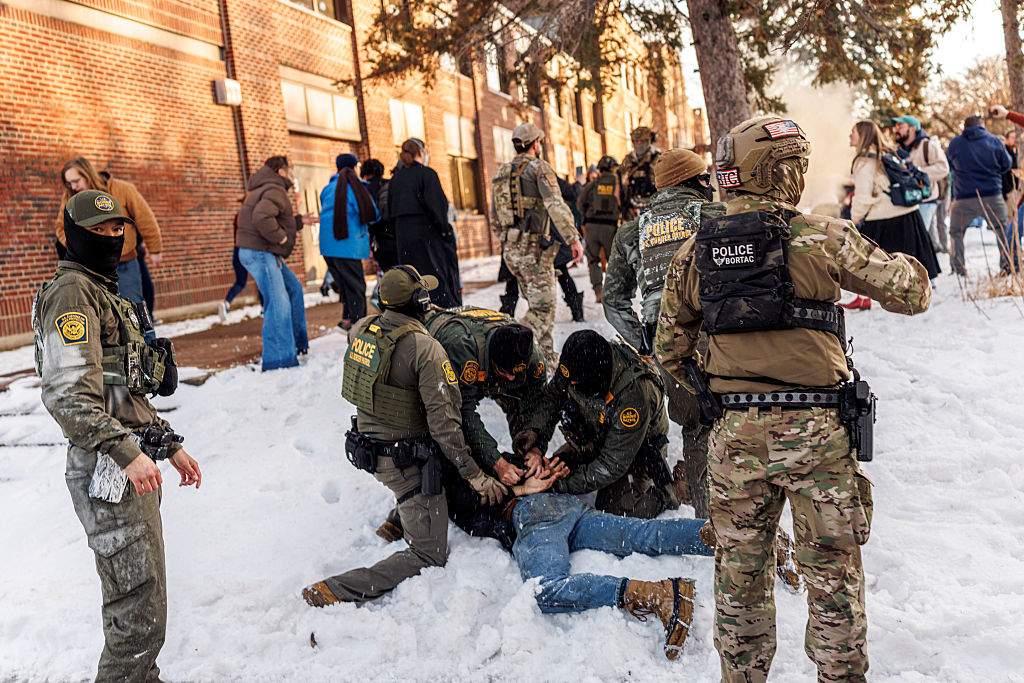 U.S. Border Patrol agents detain a person near Roosevelt High School during dismissal time as federal immigration enforcement actions sparked protests in Minneapolis, Minnesota, on January 7, 2026.