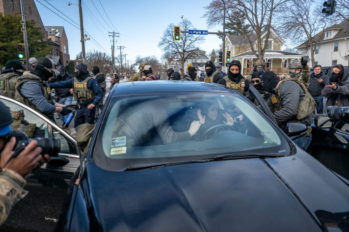 Federal law enforcement agents break a window and detain a motorist in a vehicle during a raid in Minneapolis, Minnesota, US, on Tuesday, Jan. 13, 2026.