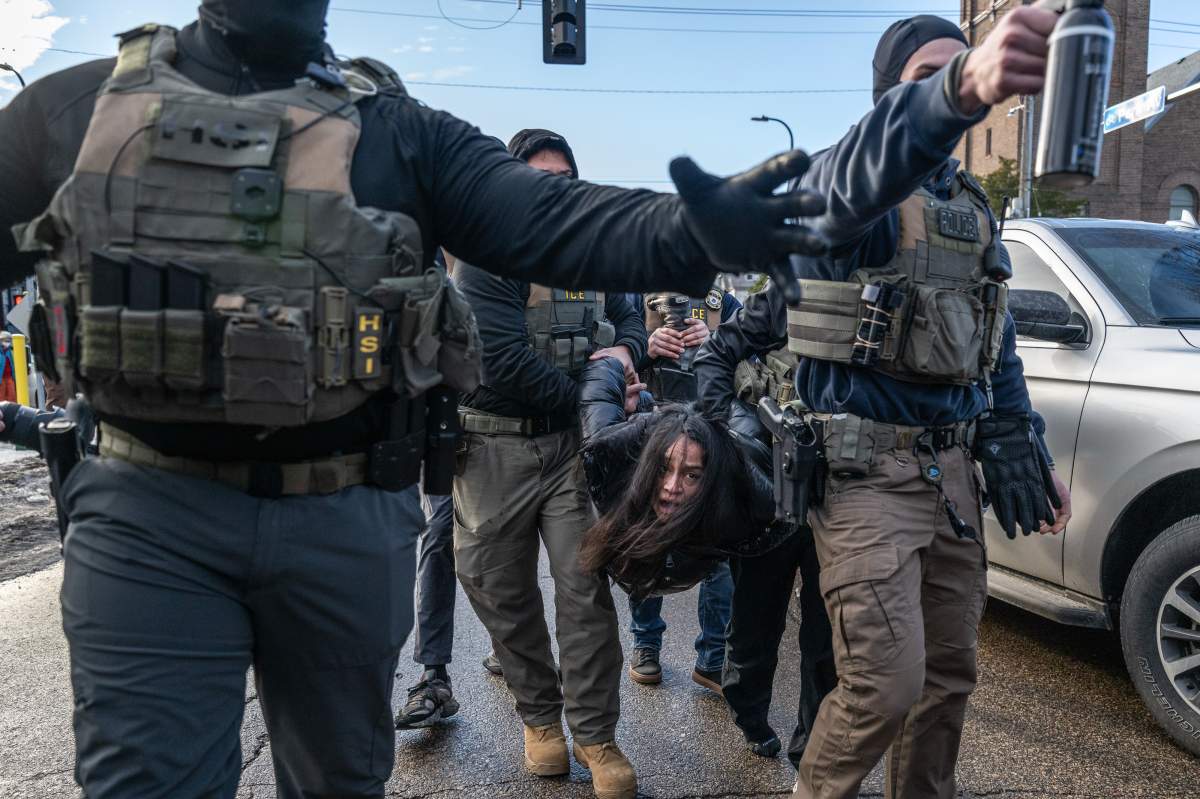 Federal law enforcement agents detain a motorist from a vehicle during a raid in Minneapolis, Minnesota, US, on Tuesday, Jan. 13, 2026.