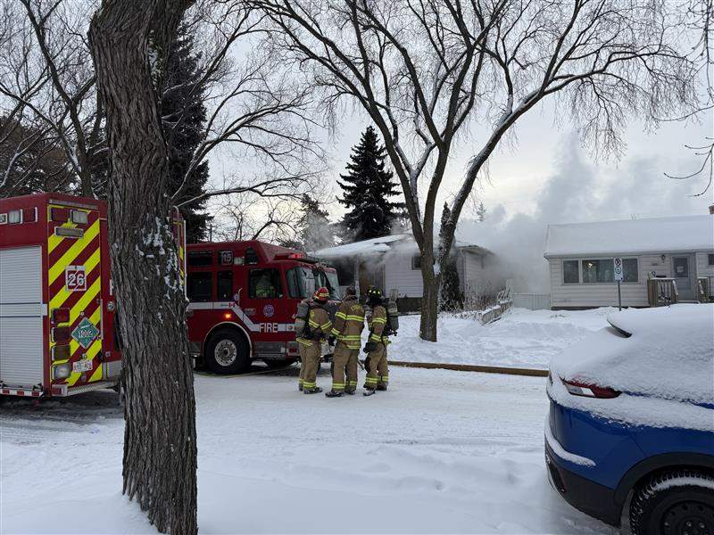 Edmonton Fire Fighters stand outside a house fire in Edmonton's Argyll neighbourhood. January 3, 2026.