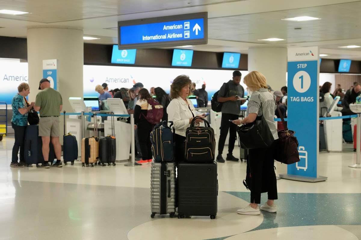 Passengers check in at the American Airlines ticket counter at Phoenix Sky Harbor International Airport Saturday, Nov. 8, 2025, in Phoenix.