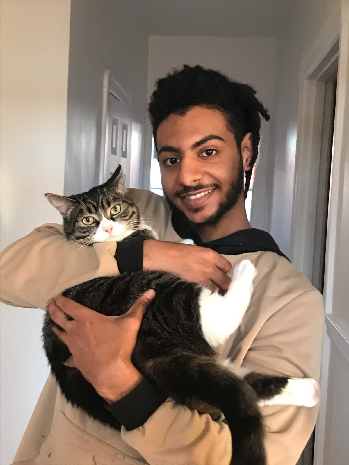 Undated photo of Ahmed Ali holding a cat.