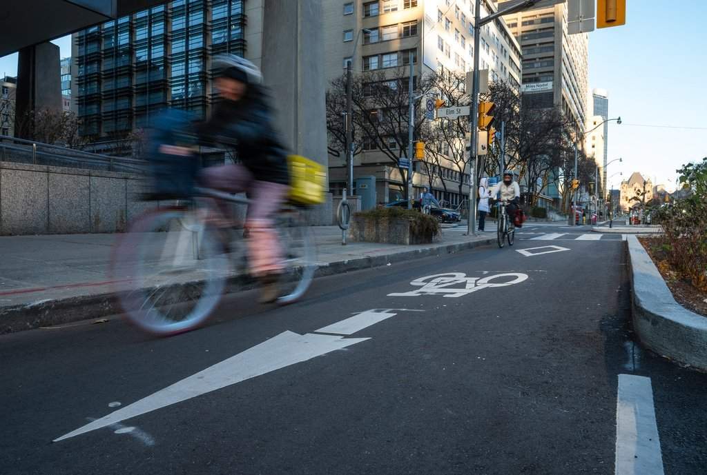 A cyclist rides in a bike lane on University Avenue in Toronto on Friday, December 13, 2024. THE CANADIAN PRESS/Laura Proctor.