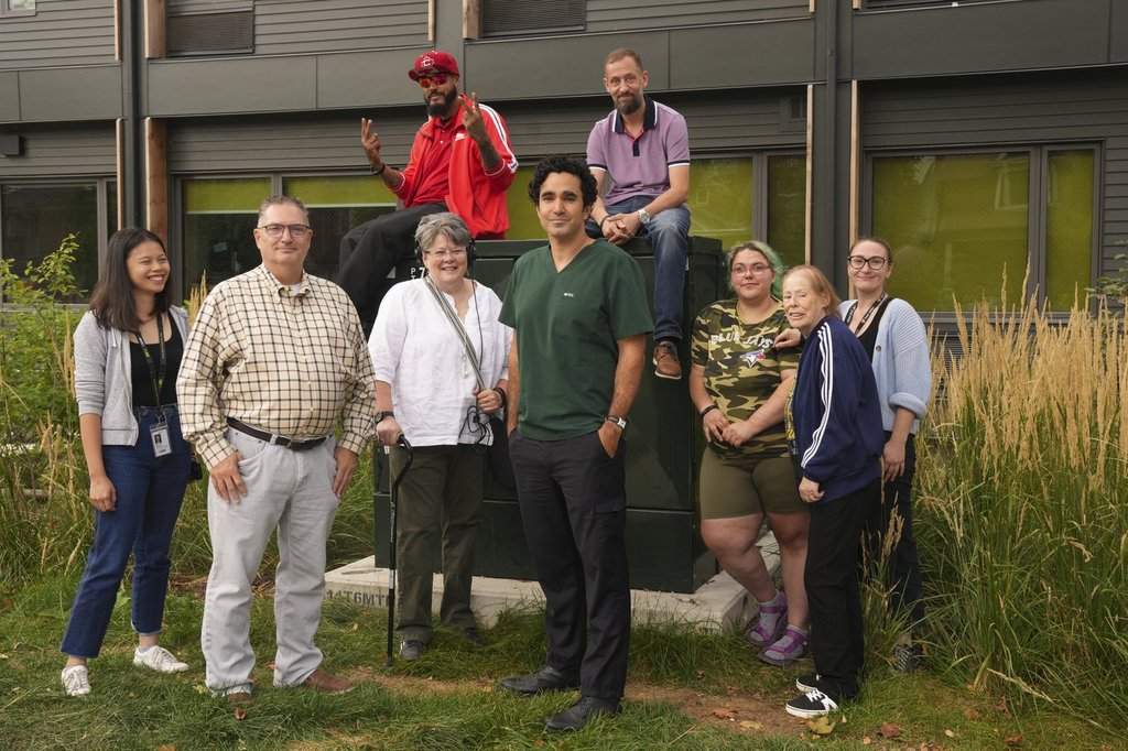 Tenants and staff are photographed outside Dunn House, Canada's first social medicine housing project, in Toronto on Thursday, Sept. 18, 2025. Evelyn Cheung, front left to right, Keith Hambly, Michelle Walda, Dr. Andrew Boozary, Maggie-Mae Coles, Genevieve Baker, and Avery Ptolemy. Matthew Lihou, rear left to right, and Jason Miles. THE CANADIAN PRESS/Chris Young.