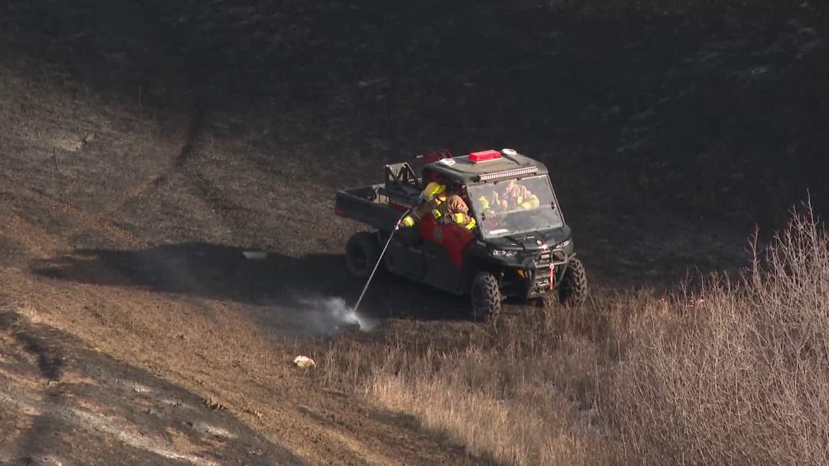 Firefighters in Lethbridge are seen mopping up hot spots from a fire that investigators believe started at a homeless encampment near Scenic Drive and 10 Avenue South on Jan. 13.