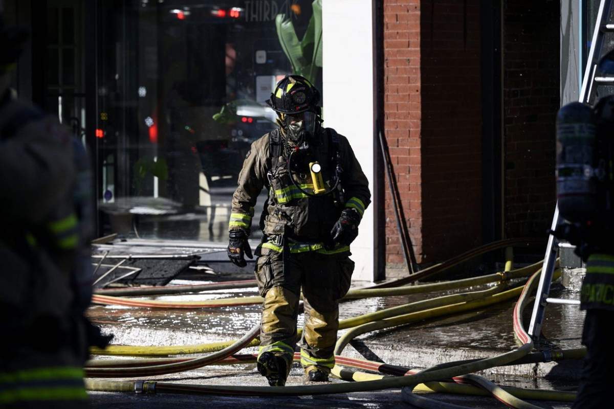 A firefighter works at the scene of a fire in a commercial building in Ottawa's Glebe neighbourhood, on Sunday, March 24, 2024.