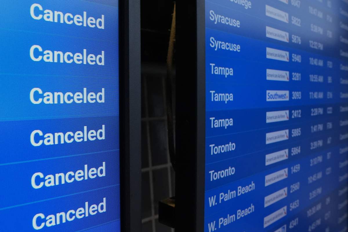 A flight status screen shows canceled flights at Philadelphia International Airport during a winter storm in Philadelphia, Sunday, Jan. 25, 2026.
