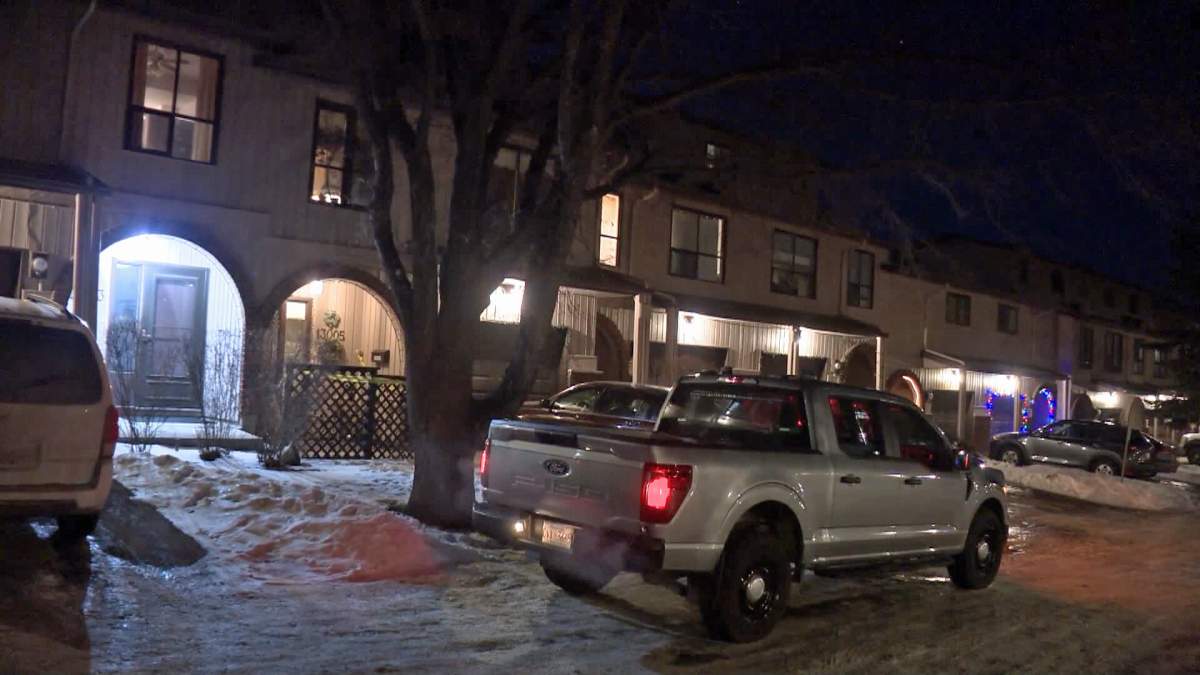 A Calgary police vehicle is seen outside a home in the community of Canyon Meadows where investigators say they death of woman in her 80s was determined to be a domestic homicide.