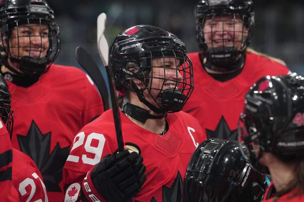 Canada's Marie-Philip Poulin (29) gathers with teammates during warmups before a preliminary round match of women's ice hockey against Czechia at the 2026 Winter Olympics, in Milan, Italy, Monday, Feb. 9, 2026. (AP Photo/Carolyn Kaster).