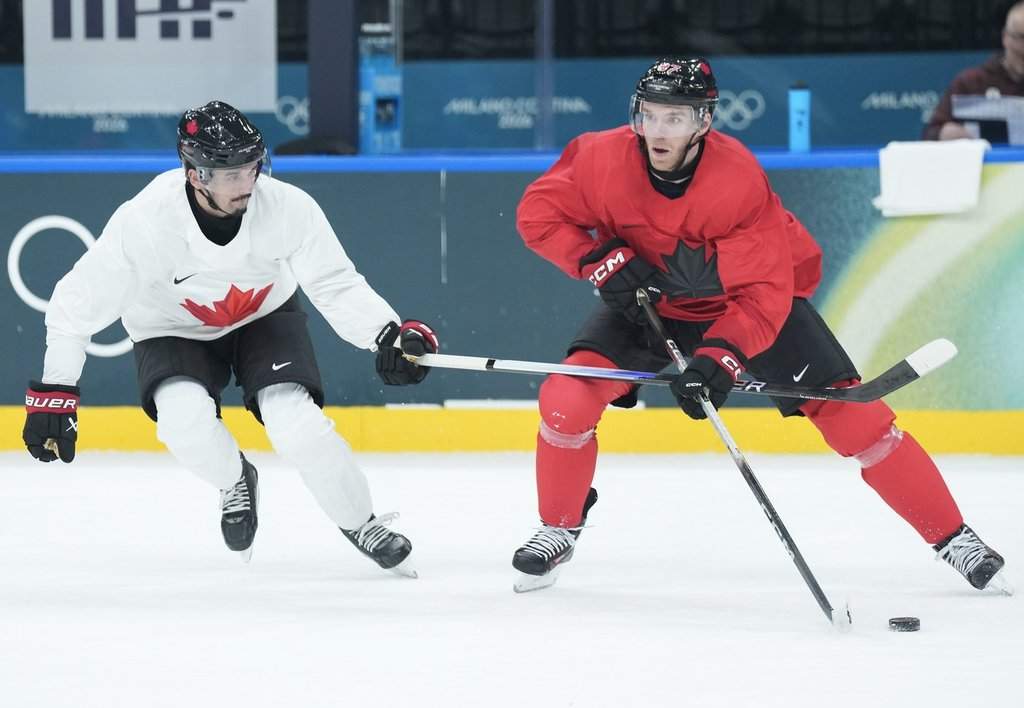 Canadian forward Connor McDavid, right, drives past teammate Seth Jarvis during practice at the 2026 Milan Cortina Winter Olympics in Milan on Sunday, Feb. 8, 2026. THE CANADIAN PRESS/Nathan Denette.