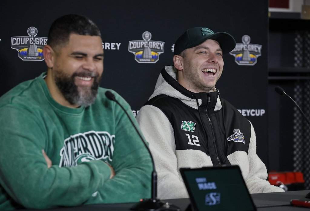 Saskatchewan Roughriders' Brett Lauther, right, jokes with head coach Corey Mace as they speak to media after their Grey Cup practice in Winnipeg, Friday, Nov. 14, 2025. THE CANADIAN PRESS/John Woods.