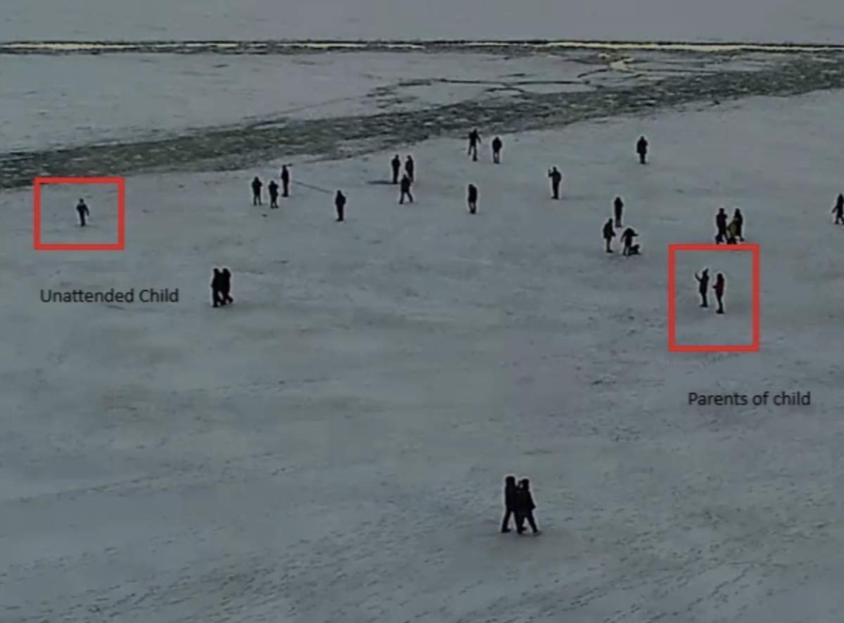 An image shared by Toronto Police show a child unsupervised close to the edge of the ice as their parents take photos several ft away.