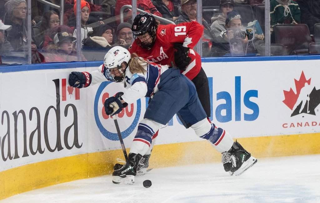 United States' Haley Winn (8) and Canada's Brianne Jenner (19) battle for the puck during third period Rivalry Series action in Edmonton on Saturday, Dec. 13, 2025. THE CANADIAN PRESS/Jason Franson.