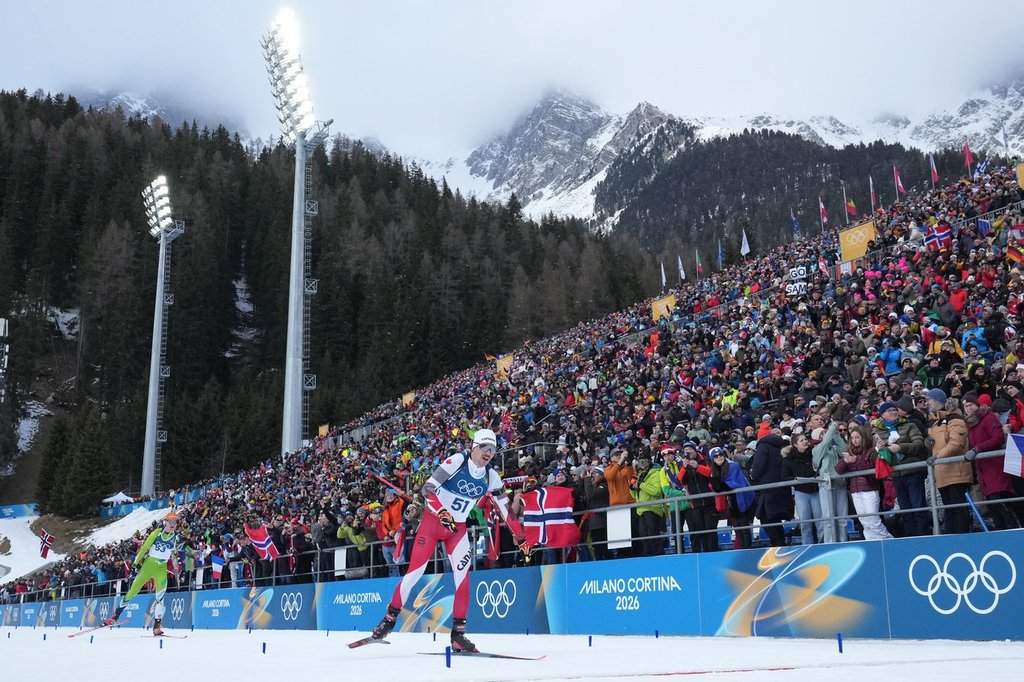 Adam Runnalls, of Canada, crosses the finish line in the men's 20-kilometer individual biathlon race at the 2026 Winter Olympics in Anterselva, Italy, Tuesday, Feb. 10, 2026. (AP Photo/David J. Phillip).