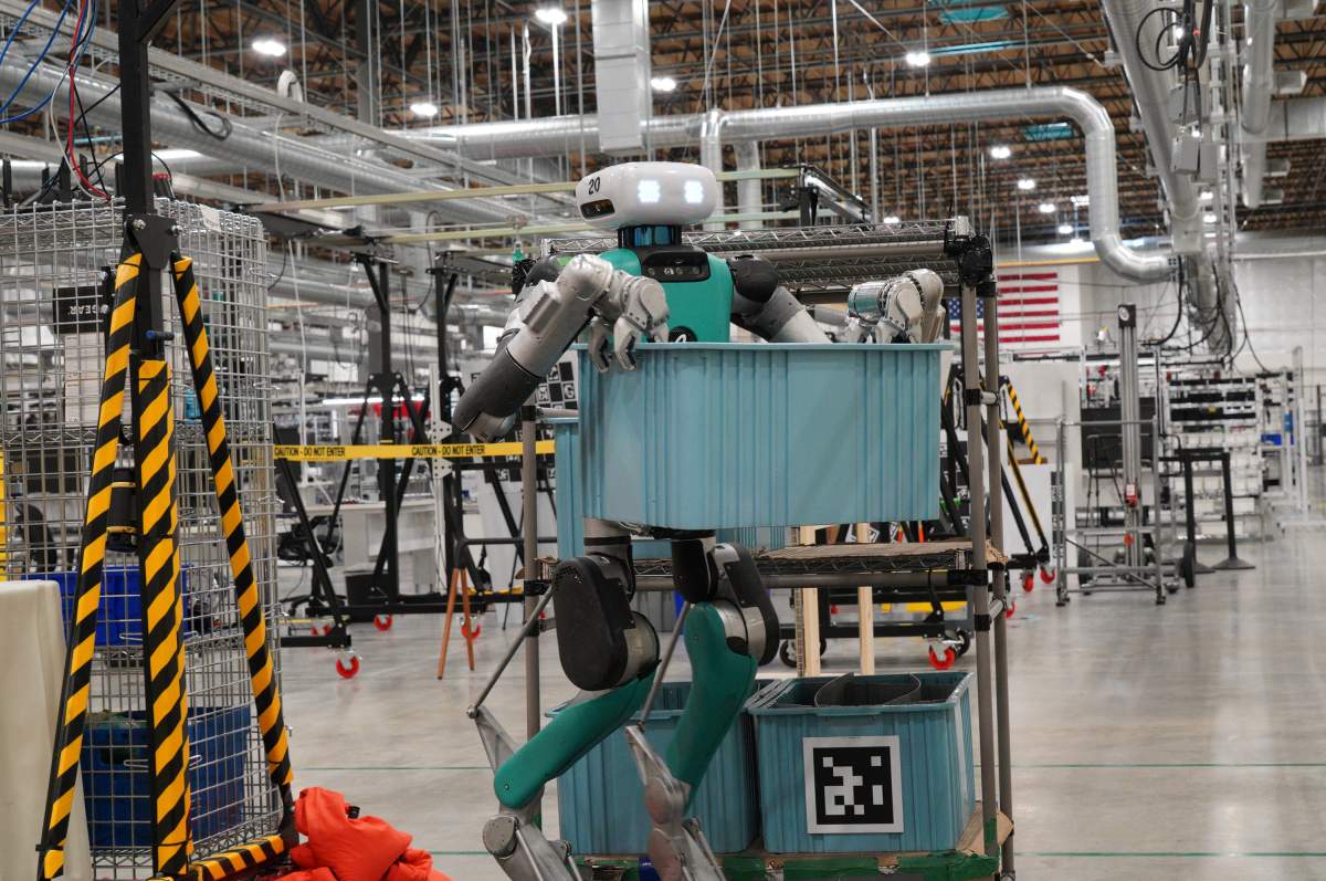 Digit, a humanoid robot developed by Agility Robotics, performs material-handling tasks inside a manufacturing facility.