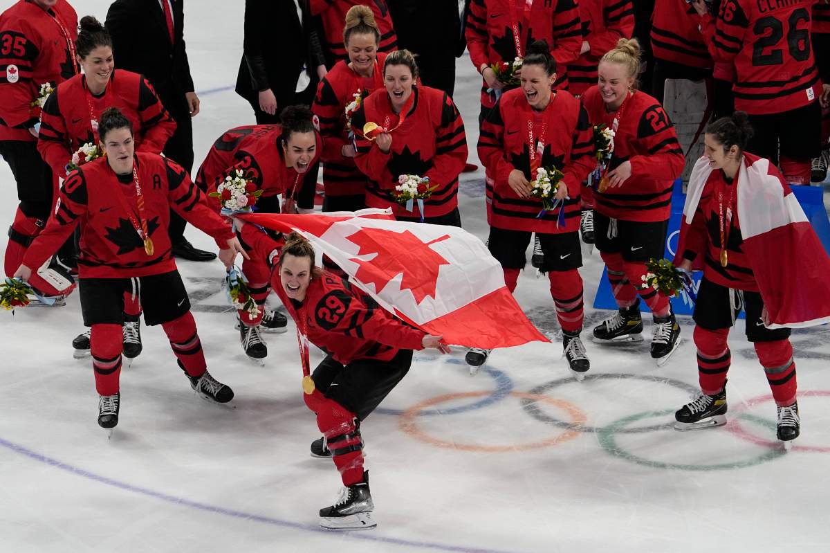 Canada’s Marie-Philip Poulin (29) poses with her team after defeating the United States in the women’s gold medal hockey game at the 2022 Winter Olympics on Feb. 17, 2022, in Beijing.