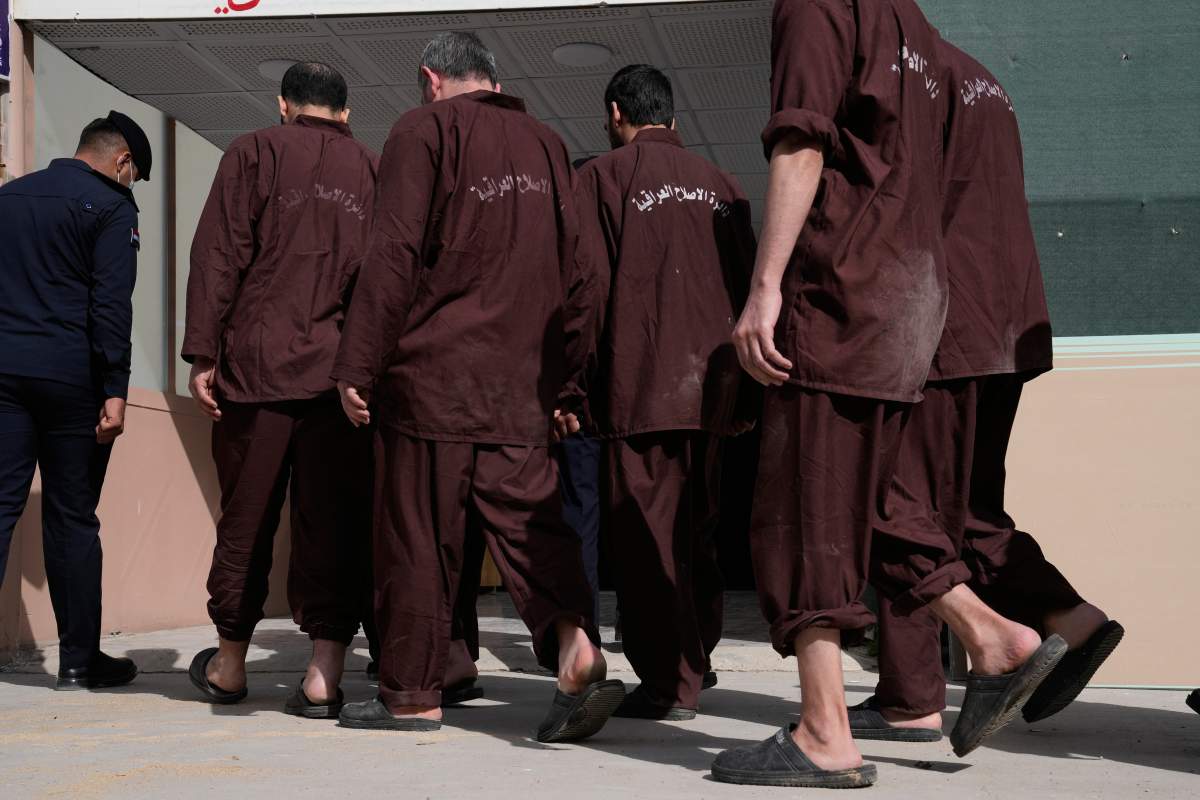 Iraqi security forces lead suspected Islamic State militants for questioning after they were transferred from Syria to Iraq, at Al-Karkh Central Prison in Baghdad, Iraq, Feb. 12, 2026. (AP Photo/Hadi Mizban)