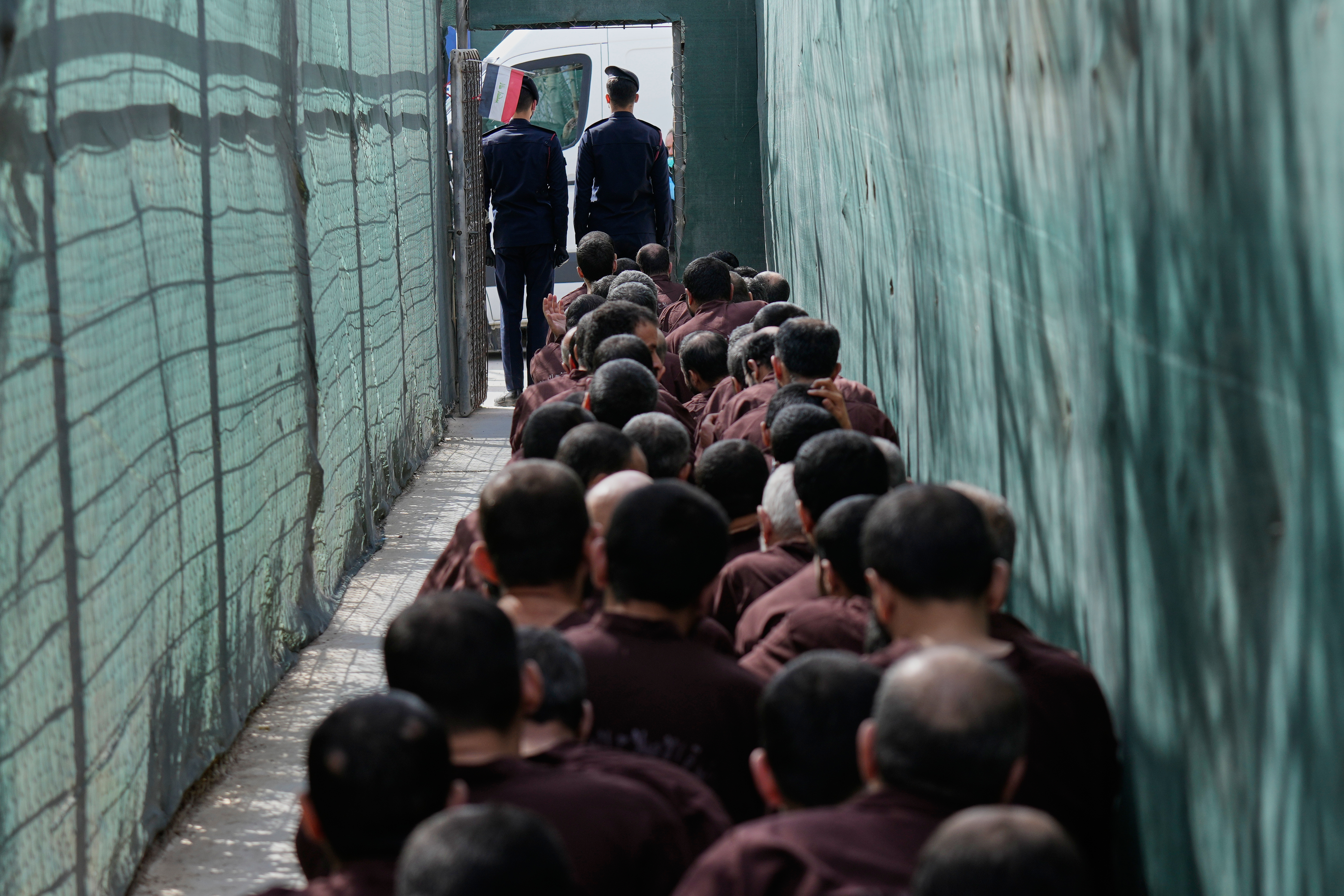 Iraqi security forces lead suspected Islamic State militants for questioning, after they were transferred from Syria to Iraq, at Al-Karkh Central Prison in Baghdad, Iraq, Thursday, Feb. 12, 2026. (AP Photo/Hadi Mizban)