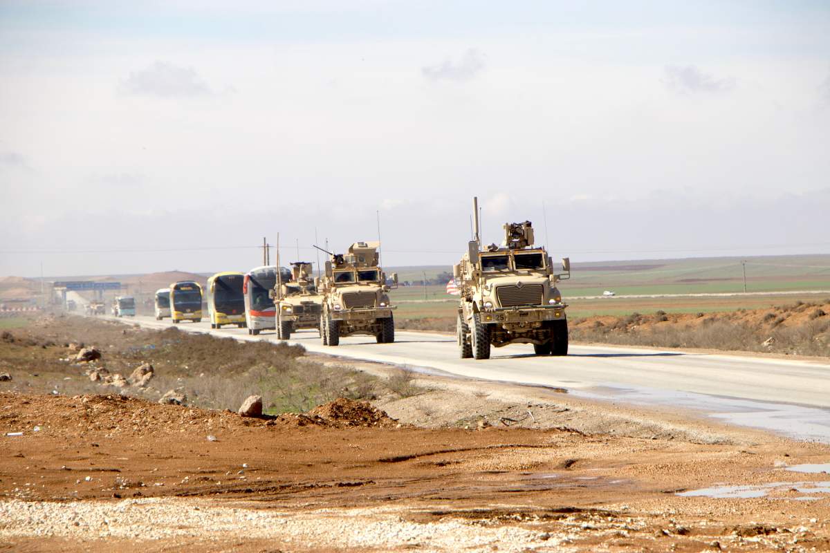 U.S. military vehicles escort passenger buses transporting Islamic State detainees from northeastern Syria into Iraq. Feb. 8, 2026. (Credit Image: © Stringer/Xinhua via ZUMA Press)