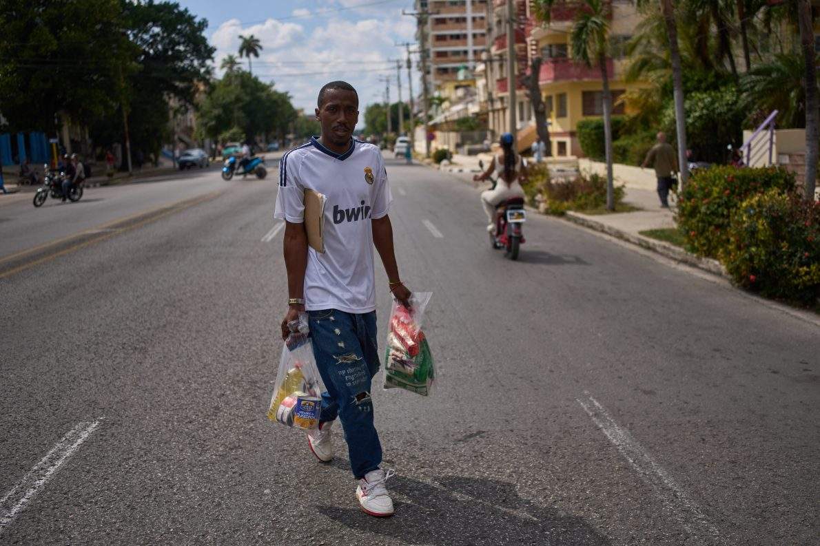 State-run bodega manager Roberto Roman carries bags of donated Mexican humanitarian assistance to be delivered to a family, in Havana, Cuba, Thursday, Feb. 19, 2026.
