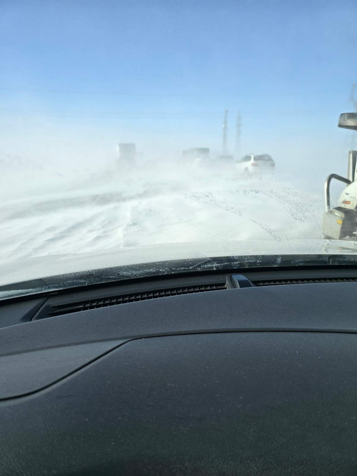 Cars stranded on Highway 1 with snow drifts forming between the cars