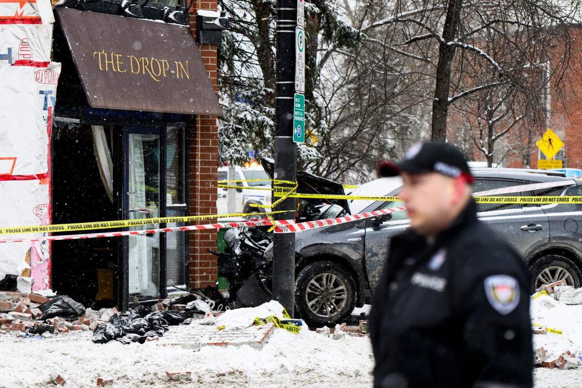 A severely damaged vehicle is pictured at the scene of a crash as officers from the Ottawa Police Service (OPS) investigate near the intersection of Rideau St., and Cobourg St., in downtown Ottawa, on Wednesday, Feb. 25, 2026. 