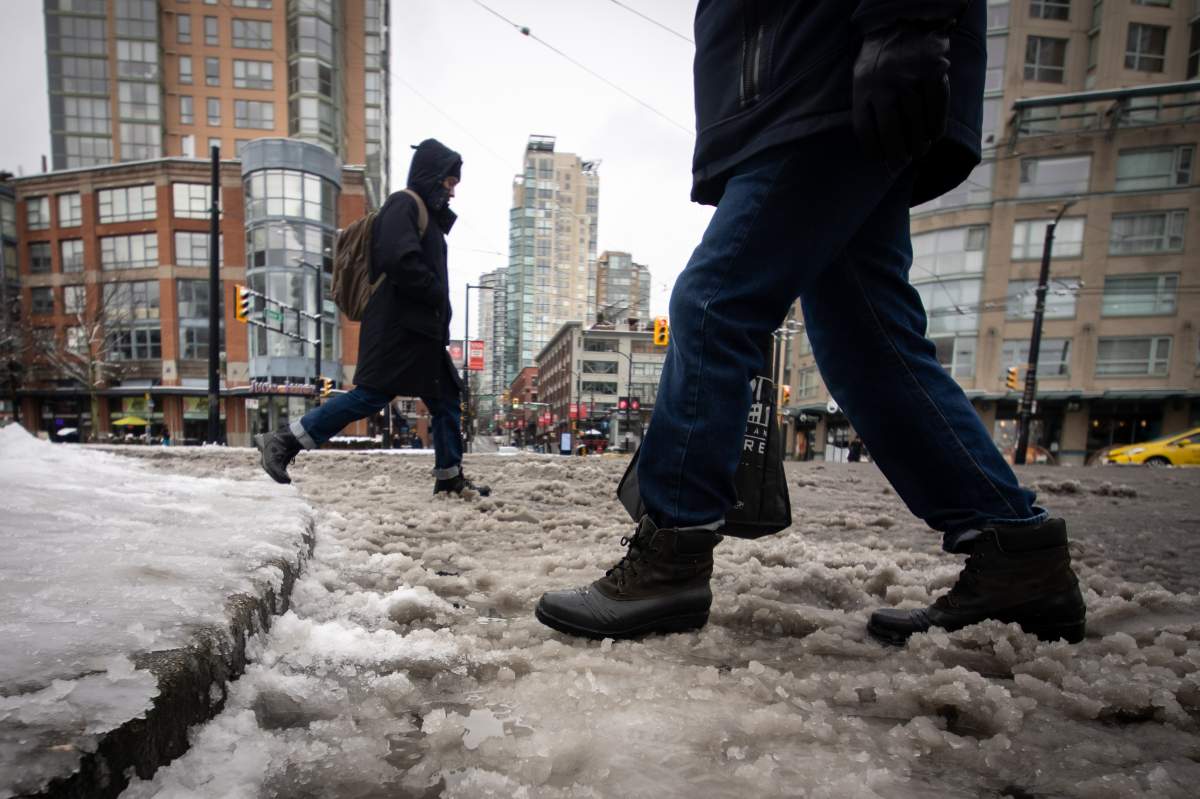 People walk through slush after some snow in Vancouver on Sunday, February 2, 2025. 