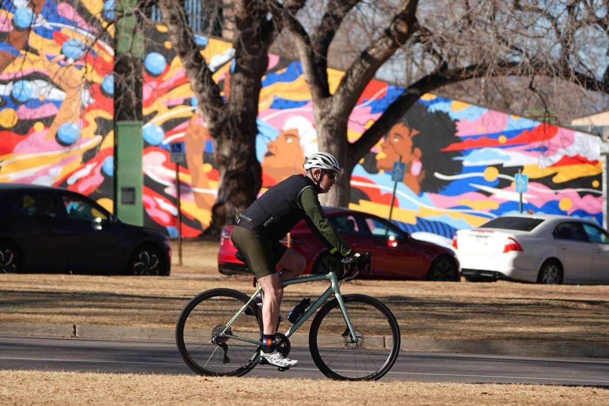Taking advantage of daytime temperatures in the mid-to-high teens Celsius, a cyclist wheels through Washington Park, Friday, Feb. 6, 2026, in Denver.