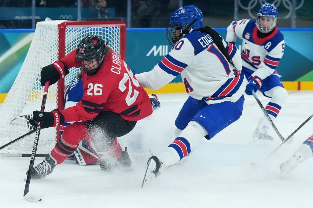 Emily Clark (26) of Team Canada tries a wrap-around as Laila Edwards (10) of Team United States defends during third period Olympic hockey action at the 2026 Milan Cortina Winter Olympics in Milan, Italy on Tuesday, Feb. 10, 2026. THE CANADIAN PRESS/Nathan Denette.