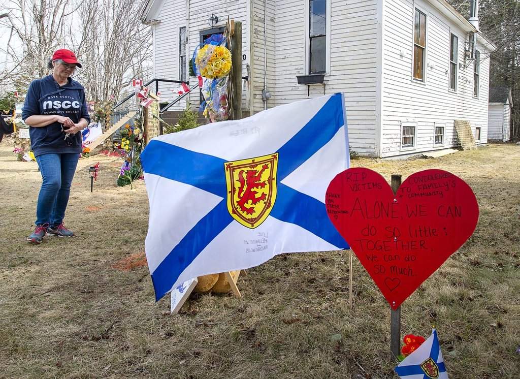 People pay their respects at a roadside memorial in Portapique, N.S., on Sunday, April 26, 2020, after a lone gunman killed 22 people in rural Nova Scotia. THE CANADIAN PRESS/Andrew Vaughan.