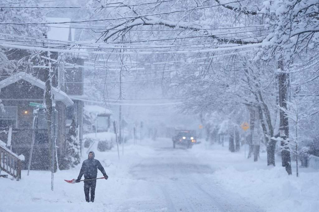 A person pauses while shovelling snow during a winter storm that closed schools and left thousands without power in Halifax on Jan. 19 2026.