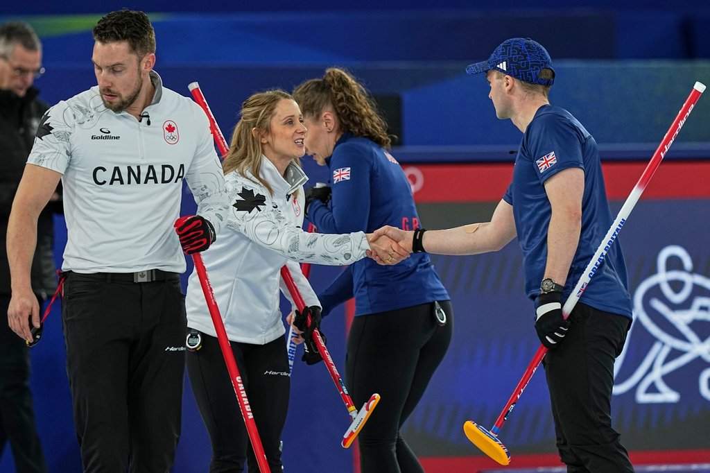 Canada's Jocelyn Peterman shakes hands with Britain's Bruce Mouat during the mixed doubles round robin phase of the curling competition at the 2026 Winter Olympics, in Cortina d'Ampezzo, Italy, Saturday, Feb. 7, 2026. (AP Photo/Fatima Shbair).