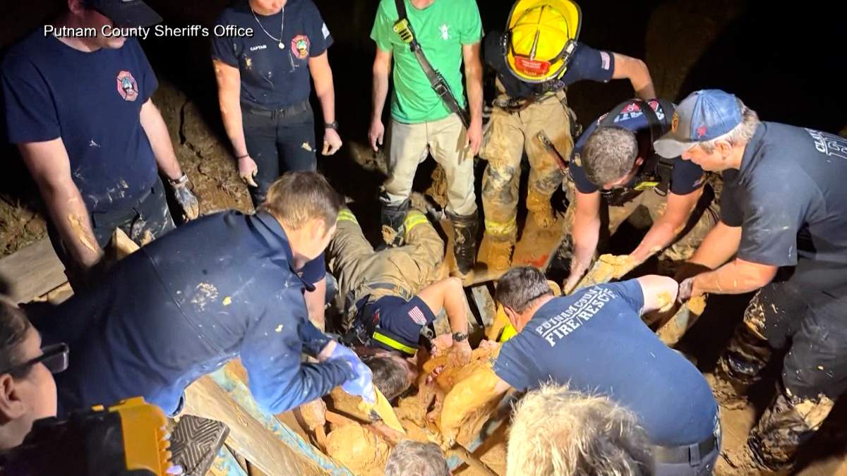Rescue staff work to remove a Florida man who became stuck in a pit of mud-like quicksand.