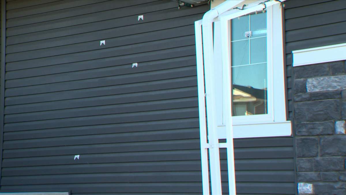 Bullet holes and crime scene markers can be seen on the outside of the home that was shot in the 100 block of Redstone Common N.E.