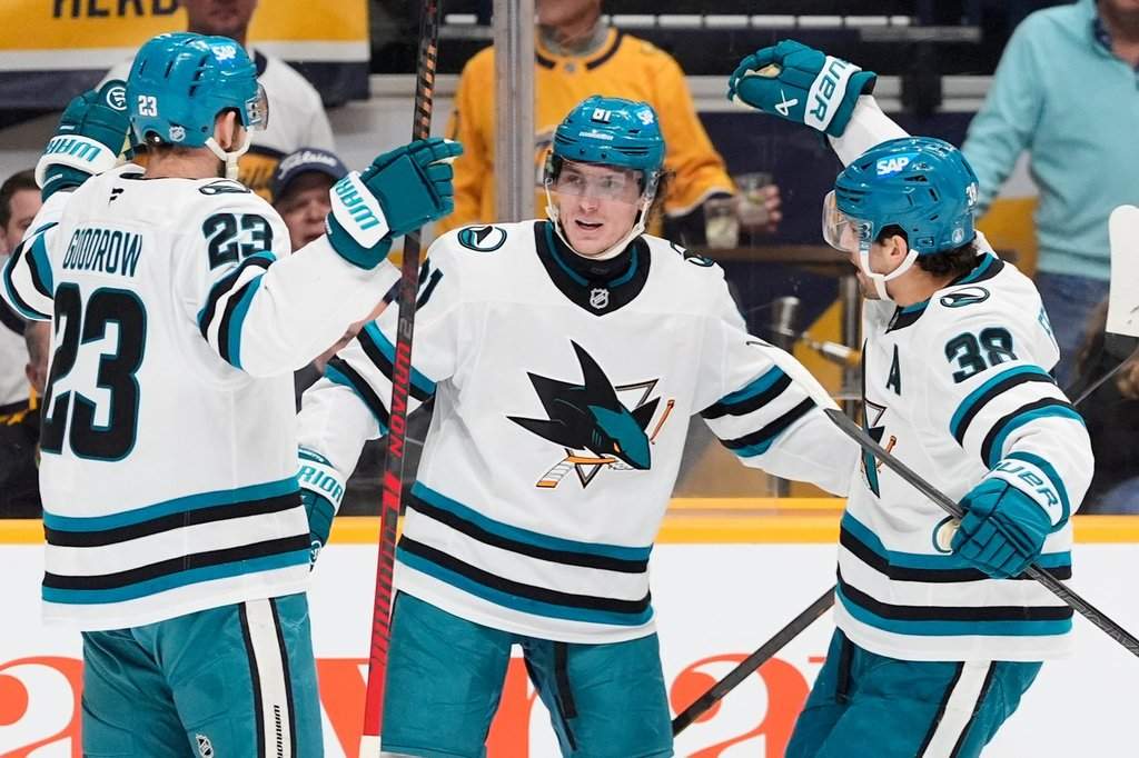 San Jose Sharks right wing Adam Gaudette (81) celebrates his goal with centre Barclay Goodrow (23) and defenceman Mario Ferraro (38) during the first period of an NHL hockey game against the Nashville Predators, Tuesday, March 24, 2026, in Nashville, Tenn.