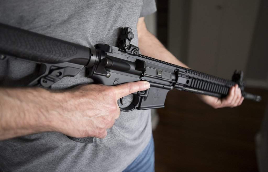 A restricted gun licence holder holds an AR-15 at his home in Langley, B.C. on May 1, 2020. THE CANADIAN PRESS/Jonathan Hayward.