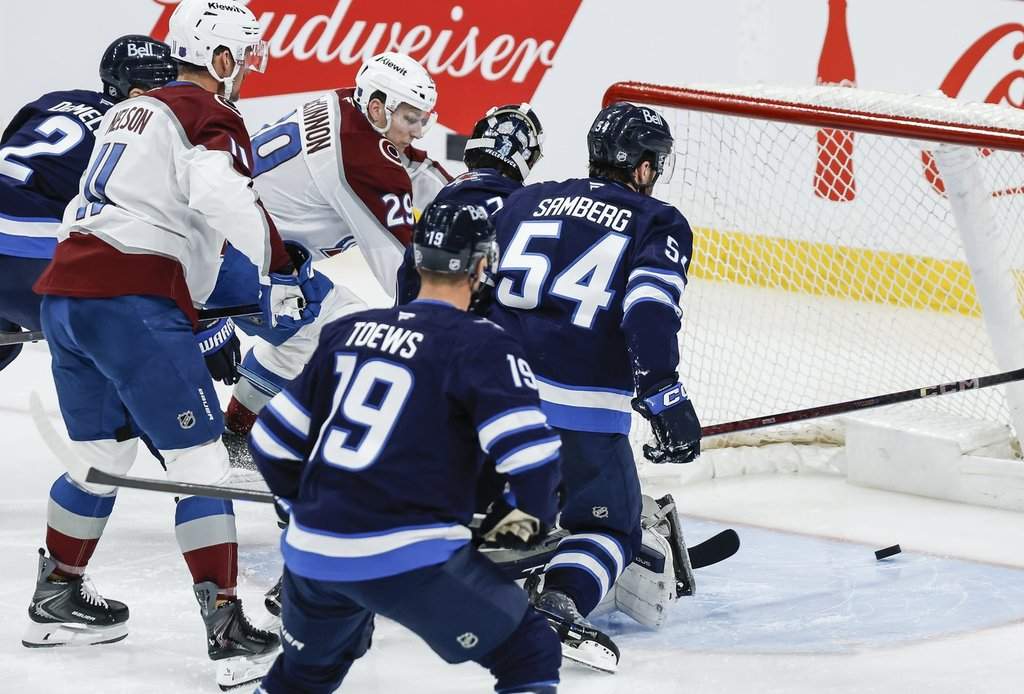 The Colorado Avalanche's Nathan MacKinnon (29) scores on Winnipeg Jets goaltender Connor Hellebuyck (37) during third-period NHL action in Winnipeg, Thursday, March 26, 2026.