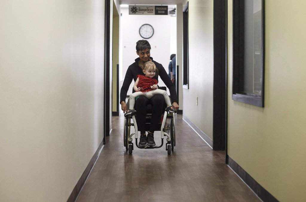 Evelyn Moore goes for a ride with Bean Gill, co-founder of ReYu Paralysis Recovery Centre in Edmonton Alta, on Wednesday April 4, 2018.