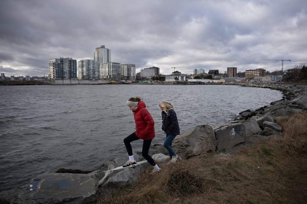 Children walk along the shoreline at Dartmouth Cove in Dartmouth, N.S. on Tuesday, December 30, 2025. THE CANADIAN PRESS/Darren Calabrese.