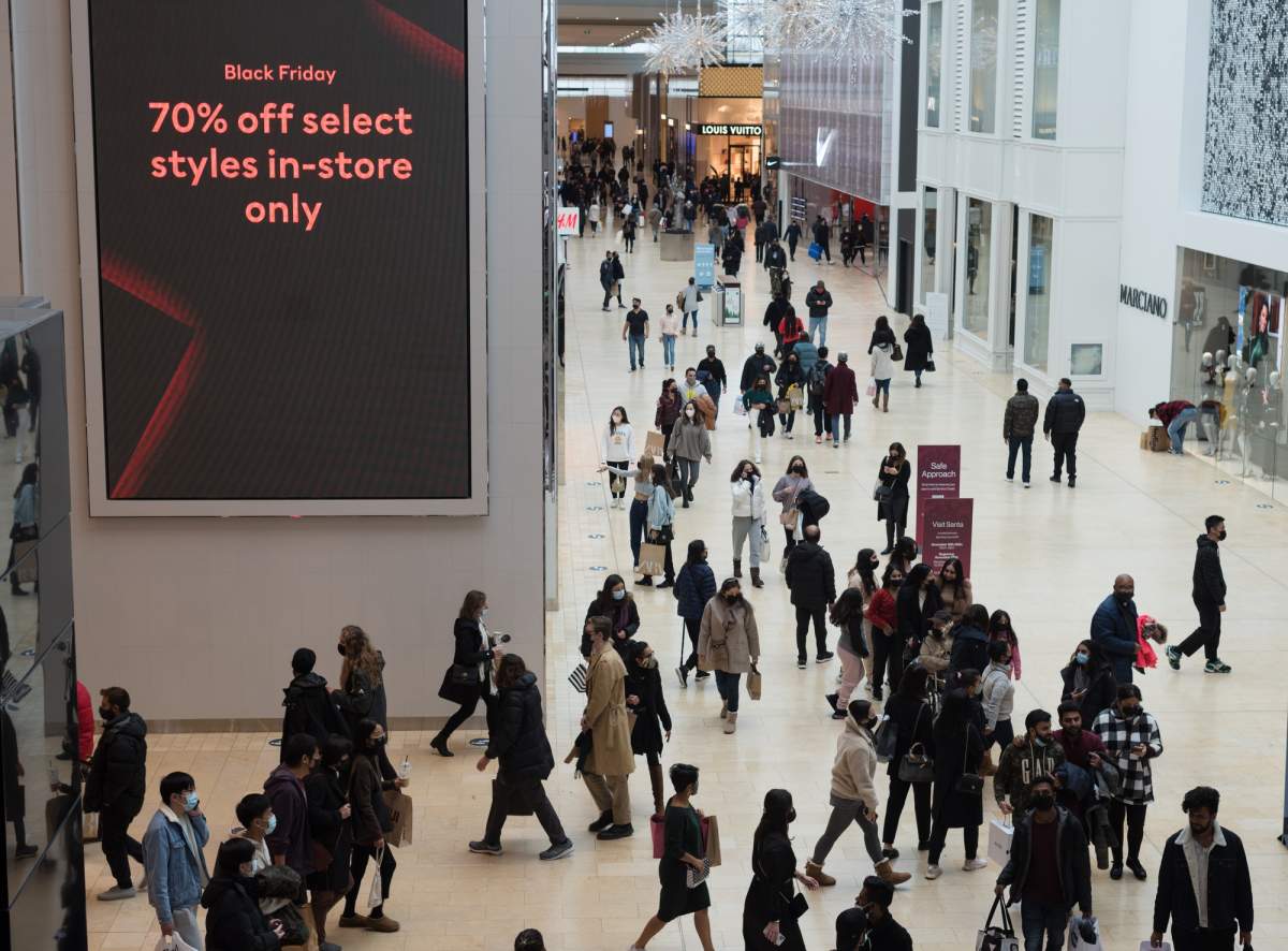 Shoppers walk through Yorkdale Mall in search of Black Friday sales in Toronto on Friday, Nov. 26, 2021. This Black Friday, retailers are promising its usual wave of discounts, door crashers and sales timed to the holiday season. However, the annual shopping bonanza comes as Canadians are feeling particularly stressed about money.