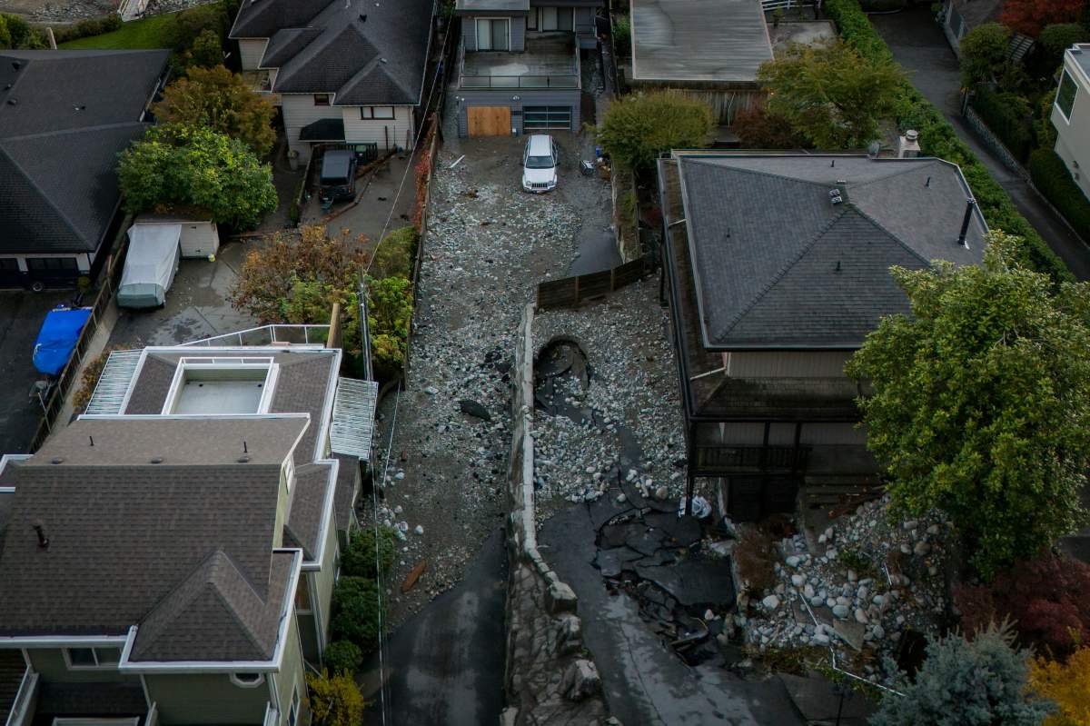 Multiple homes are seen surrounded by debris left by flooding from torrential rain from an atmospheric river weather system at Deep Cove in North Vancouver, on Tuesday, October 22, 2024.
