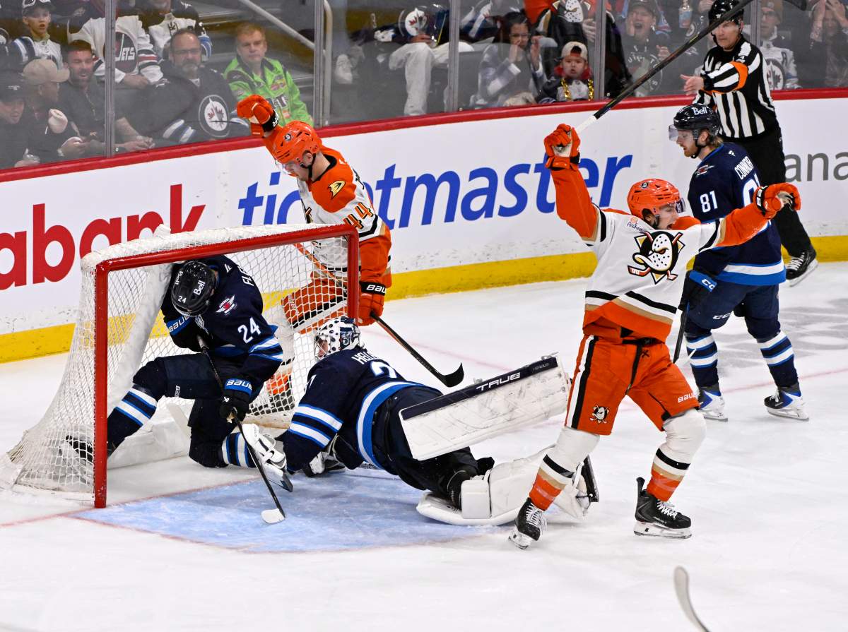 Anaheim Ducks' Tim Washe (front right) celebrates his goal on Winnipeg Jets goaltender Connor Hellebuyck (37) as Haydn Fleury (24) falls into the net during the second period of their NHL hockey game in Winnipeg, Tuesday March 10, 2026. THE CANADIAN PRESS/Fred Greenslade.