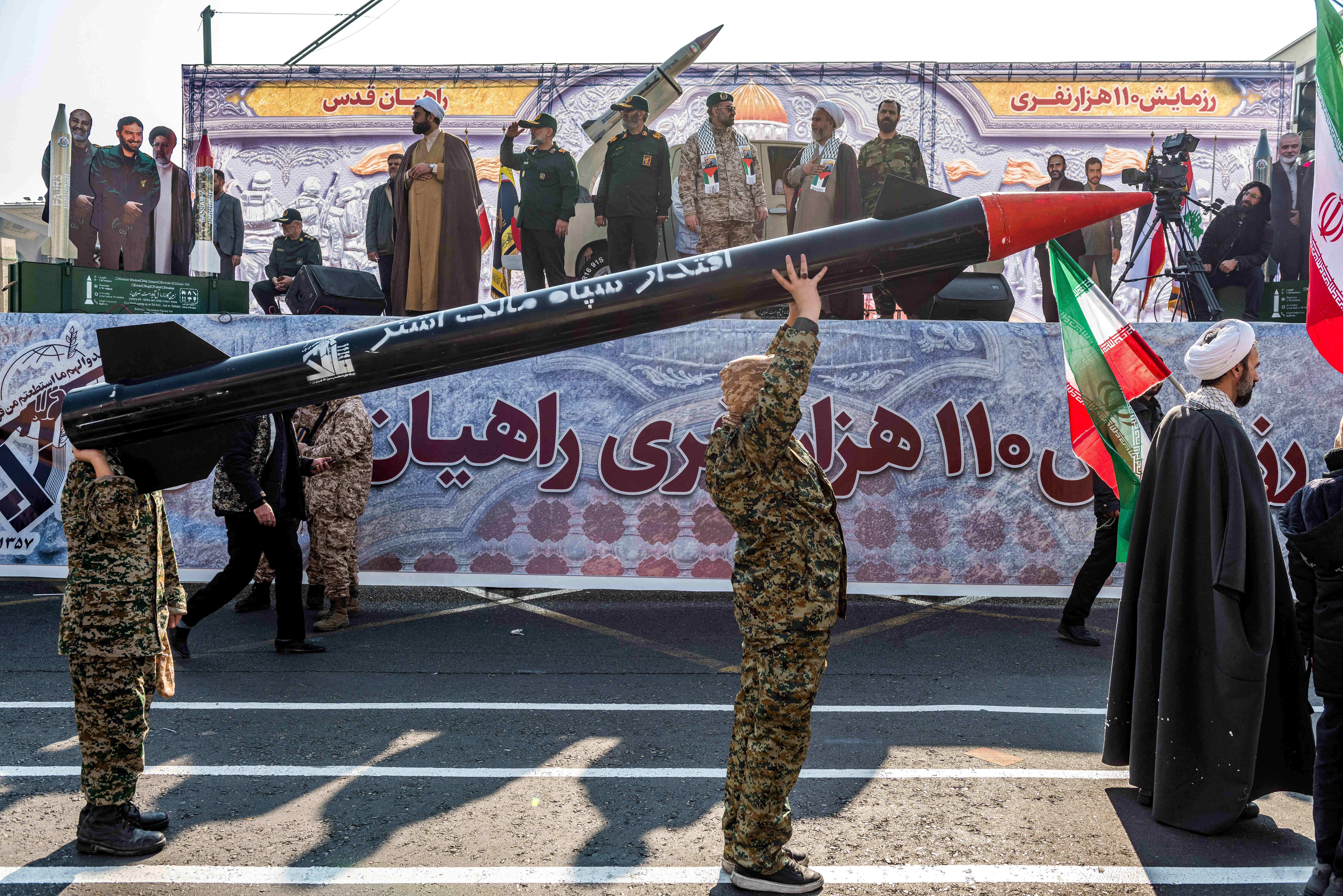 Iranian Basiji men carry mock missile, trailing cleric, at parade Tehran, Iran, Jan. 10, 2025. Photo by Hossein Beris/Middle East Images/ABACAPRESS.COM